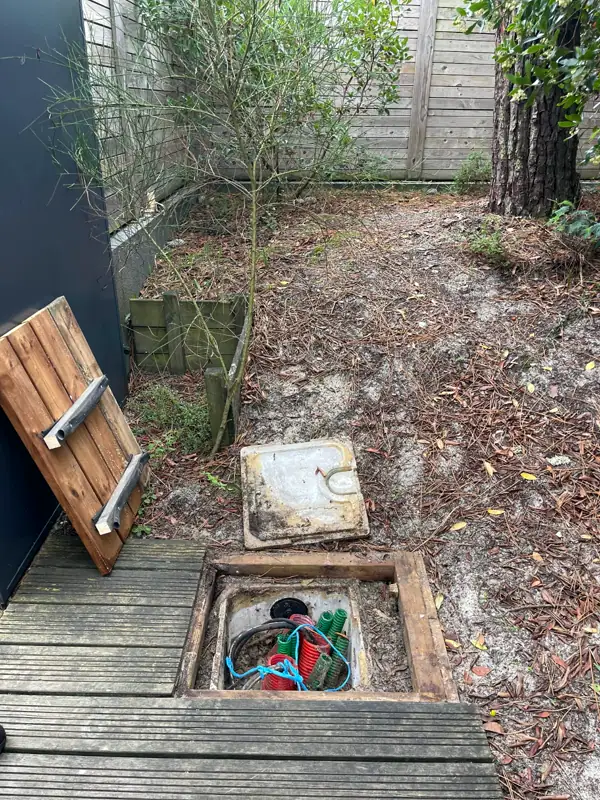 Regard télécom dégagé et ouvert dans un jardin